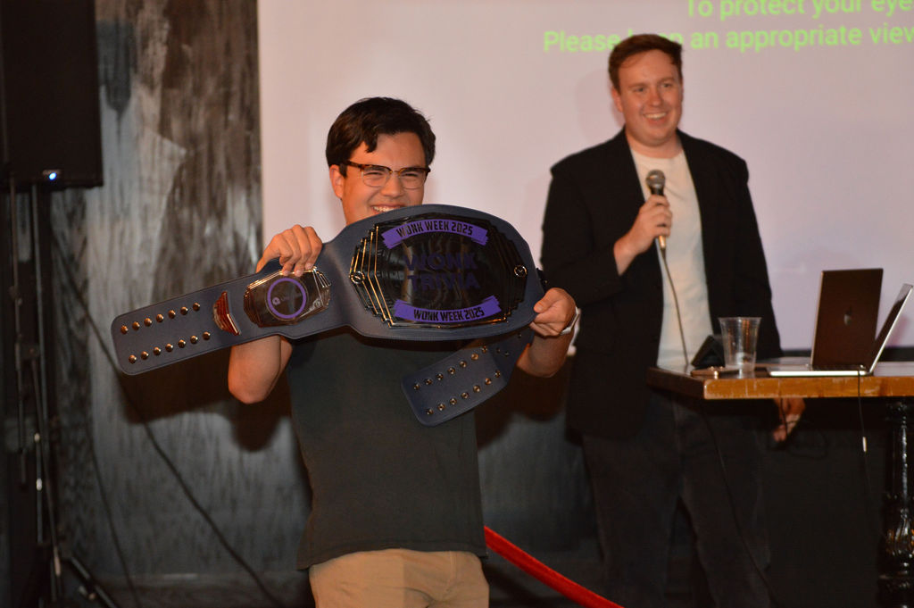 Wonk Week trivia champion hoisting the Political Trivia Belt on stage